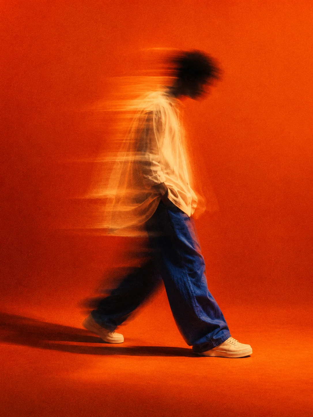 Un artista en movimiento, suspendido entre la luz y la sombra.